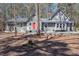 Charming home featuring a gray exterior, gable roof, red door, and well-maintained landscaping in a serene wooded setting at 9501 Coachway, Chapel Hill, NC 27516