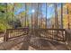 A wooden deck sits behind a home, with tall trees and sunlight providing a scenic backdrop at 1001 Atchison St, Garner, NC 27529