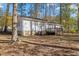 Spacious backyard features mature trees, wooden deck, and view of the home's exterior at 1001 Atchison St, Garner, NC 27529