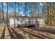 Backyard featuring the house with a wooden deck and shade provided by mature trees at 1001 Atchison St, Garner, NC 27529