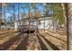 A backyard view showing the home's deck, siding, and tree-lined property at 1001 Atchison St, Garner, NC 27529