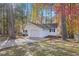 Charming single-story home with white siding, attached garage, and a driveway surrounded by colorful trees at 1001 Atchison St, Garner, NC 27529