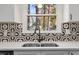 Close-up of kitchen sink with decorative backsplash and a view of the outdoors at 1001 Atchison St, Garner, NC 27529