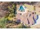 Aerial view showcasing a backyard pool, patio with umbrellas, and a meticulously landscaped yard at 1001 Welch Ln, Raleigh, NC 27614