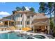 Luxury home's backyard features a sparkling pool, spa, and covered outdoor living area at 1001 Welch Ln, Raleigh, NC 27614