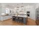 Stylish kitchen boasts a gray island with seating, hardwood floors, and stainless steel appliances at 1001 Welch Ln, Raleigh, NC 27614