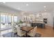 Bright kitchen features a gray island with seating, stainless steel appliances, and a dining area with backyard views at 1001 Welch Ln, Raleigh, NC 27614