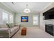 Comfortable living room with a stone fireplace, tv, and large windows at 1001 Welch Ln, Raleigh, NC 27614