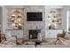 Cozy living room with a stone fireplace flanked by built-in shelving and a large TV at 1001 Welch Ln, Raleigh, NC 27614