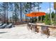 Outdoor poolside bar with seating, perfect for entertaining with a backdrop of tall trees at 1001 Welch Ln, Raleigh, NC 27614