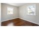 Bedroom with hardwood floors and natural light from two windows at 1004 Helms Pl, Raleigh, NC 27610