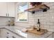 Close-up of kitchen countertop with granite counters, subway tile backsplash, and open shelving at 1004 Helms Pl, Raleigh, NC 27610