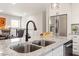 Kitchen island featuring a stainless steel sink, granite countertops, and seating at 1004 Helms Pl, Raleigh, NC 27610