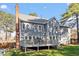 Two-story home with gray siding, brick chimney, a deck, and a well-maintained backyard at 101 Weatherly Pl, Cary, NC 27518