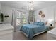 Cozy bedroom featuring a chandelier, white curtains, and bright natural light at 101 Weatherly Pl, Cary, NC 27518