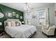 Stylish bedroom with an accent wall, queen bed, chandelier, and natural light at 101 Weatherly Pl, Cary, NC 27518