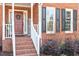 Welcoming front porch with red brick steps, white railings, and decorative details at 101 Weatherly Pl, Cary, NC 27518