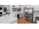 Bright kitchen with stainless steel appliances, a quartz countertop, and open shelving at 101 Weatherly Pl, Cary, NC 27518