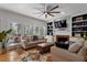 Comfortable living room with a ceiling fan, fireplace, built-in shelving, and multiple windows at 101 Weatherly Pl, Cary, NC 27518