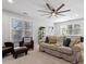 Bright living room with plush furniture, a ceiling fan, and three large windows at 101 Weatherly Pl, Cary, NC 27518