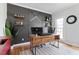 Home office featuring a modern desk, black accent wall, wall shelves, and hardwood floors at 101 Weatherly Pl, Cary, NC 27518