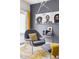 Close up of modern gray chair with ottoman, soft yellow accents, and an interesting art display on the wall at 1019 Navigon Dr, Durham, NC 27713