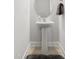 Clean powder room boasts a pedestal sink, a round mirror, and a soft gray rug on a tile floor at 1019 Navigon Dr, Durham, NC 27713