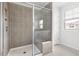 Modern tiled shower enclosure with glass door and window overlooking the backyard at 1019 Navigon Dr, Durham, NC 27713