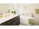 Elegant bathroom featuring dark wood cabinets, marble countertops, a freestanding bathtub, and a window at 104 Manchester Pl, Chapel Hill, NC 27516