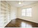 Well-lit bedroom with hardwood floors, a ceiling fan, built-in shelving, and a large window at 104 Manchester Pl, Chapel Hill, NC 27516