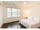 Bright bedroom with a ceiling fan, hardwood floors, and a large window overlooking the neighborhood at 104 Manchester Pl, Chapel Hill, NC 27516