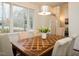 Sunlit dining room with hardwood floors, an elegant wooden table, and views of the natural surroundings at 104 Manchester Pl, Chapel Hill, NC 27516