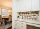 Kitchen area with modern cabinets, marble countertops, decorative tile backsplash, and open view to dining space at 104 Manchester Pl, Chapel Hill, NC 27516