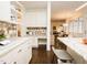 Kitchen view showcasing white cabinets, marble countertops, decorative backsplash and seamless flow into the dining and living areas at 104 Manchester Pl, Chapel Hill, NC 27516