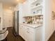 Bright kitchen featuring white cabinets, stainless steel refrigerator, decorative tile backsplash, and floating shelves at 104 Manchester Pl, Chapel Hill, NC 27516