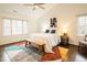 Bright main bedroom with large windows, vaulted ceilings, ceiling fan, bench, and stylish decor at 104 Manchester Pl, Chapel Hill, NC 27516