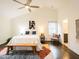 Spacious main bedroom with vaulted ceilings, ceiling fan, bench, and access to the ensuite bathroom at 104 Manchester Pl, Chapel Hill, NC 27516