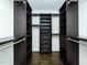 Spacious walk-in closet with custom dark wood shelving and drawers for organized storage at 104 Manchester Pl, Chapel Hill, NC 27516