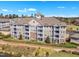 Aerial view of condo building featuring balconies and well-maintained landscaping surrounded by trees at 10421 Rosegate Ct # 303, Raleigh, NC 27617