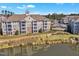 Beautiful apartment building with lakeside views, balconies, brick accents, and lush landscaping at 10421 Rosegate Ct # 303, Raleigh, NC 27617