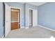 A spare bedroom featuring gray carpet, light blue walls, and closet space at 10421 Rosegate Ct # 303, Raleigh, NC 27617