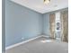 A spare bedroom featuring a gray carpet, light blue walls and bright window with patterned curtain at 10421 Rosegate Ct # 303, Raleigh, NC 27617