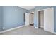 A spare bedroom featuring light blue walls, gray carpet, closet and direct access to other rooms at 10421 Rosegate Ct # 303, Raleigh, NC 27617