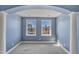 Bright bedroom with blue walls, gray carpet, and large windows looking out on a waterfront view at 10421 Rosegate Ct # 303, Raleigh, NC 27617