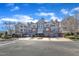 Attractive multi-story condo building with brick accents, dormer windows, and assigned parking spaces at 10421 Rosegate Ct # 303, Raleigh, NC 27617