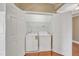 A laundry closet with double doors and washer and dryer hookups on hardwood floors at 10421 Rosegate Ct # 303, Raleigh, NC 27617