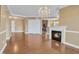 Bright living room boasts hardwood floors, fireplace, and elegant chandelier at 10421 Rosegate Ct # 303, Raleigh, NC 27617