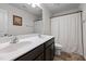 Bright bathroom featuring a double sink vanity, large mirror, and a shower with white curtain at 1055 Kerr St, Burlington, NC 27215