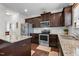 Modern kitchen boasts stainless steel appliances, granite countertops, dark wood cabinets, and an island at 1055 Kerr St, Burlington, NC 27215