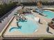 Aerial shot of a resort-style pool area featuring a slide, splash pad, and various water features at 1055 Kerr St, Burlington, NC 27215